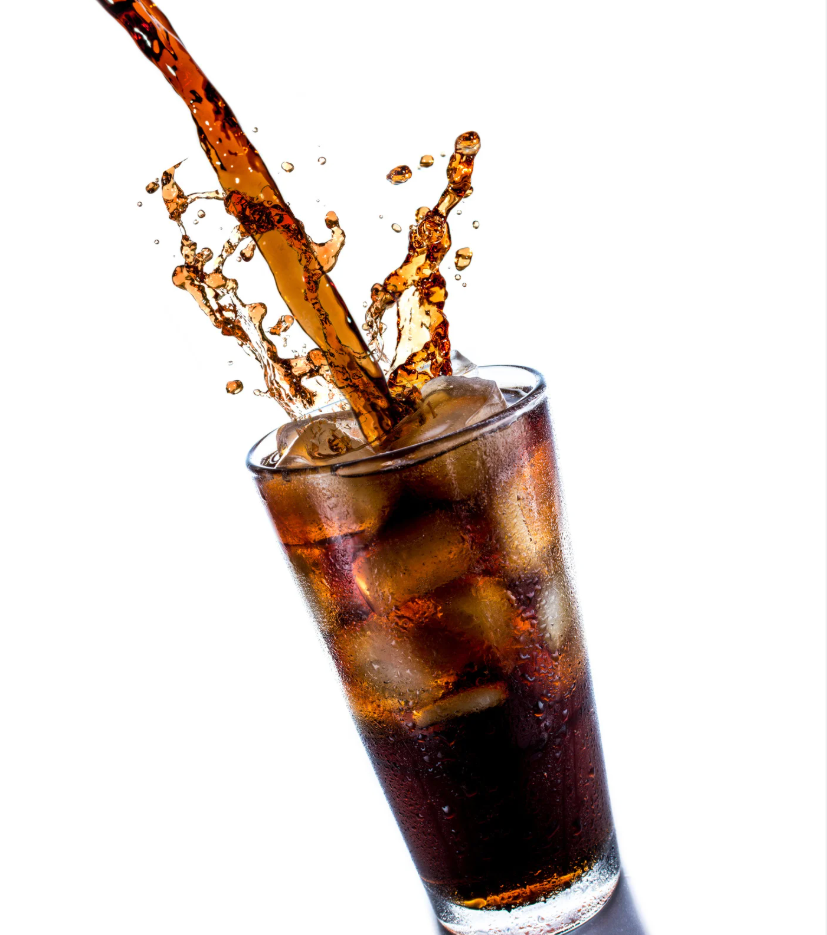 Cola splashing into a glass with ice cubes on a white background