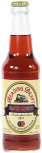 Bottle of red hot sauce with a cream label and gold cap on a white background