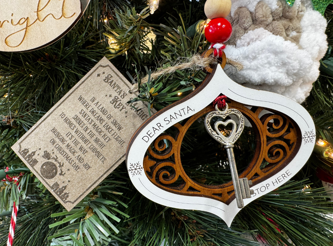 Heart-shaped white ornament with a key charm hanging on a Christmas tree, beside a vintage note tag.