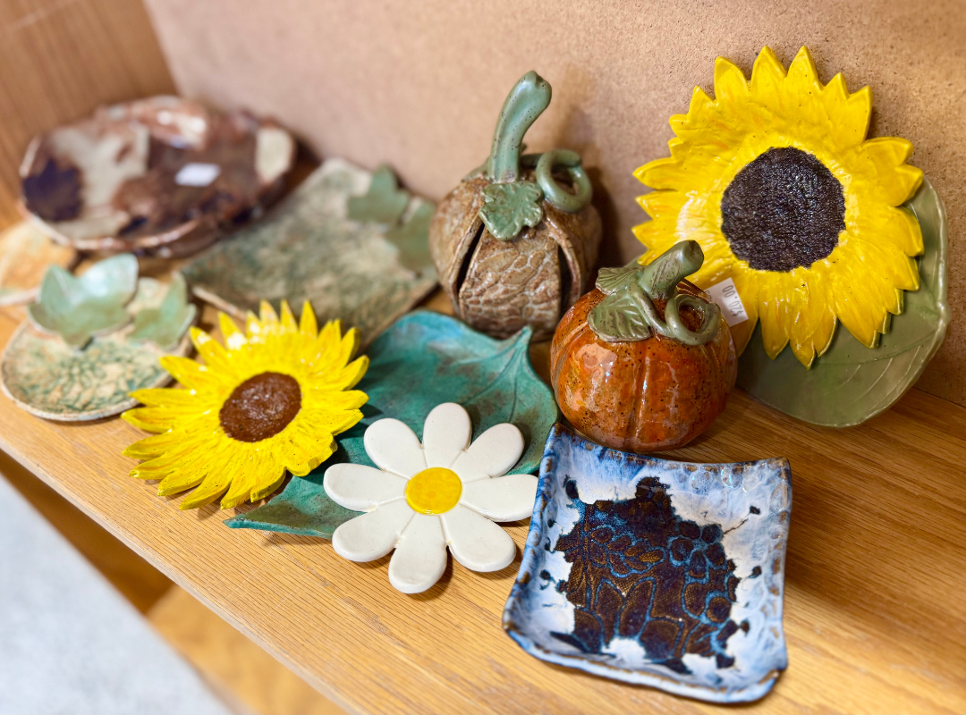 Decorative fall display with sunflowers, pumpkins, mushrooms, and a small ceramic dish