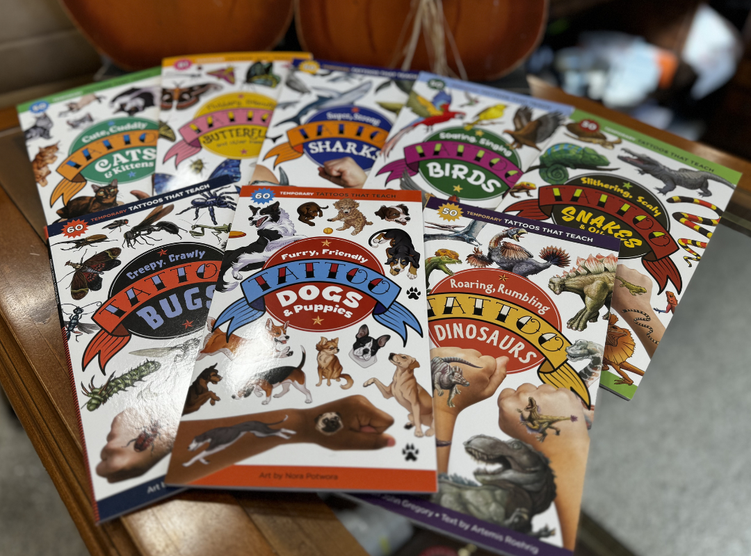 Colorful animal-themed children’s books and workbooks spread in a fan on a table