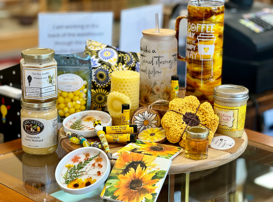 Assorted beeswax candles, honey jars, and bee-themed decor on a table display