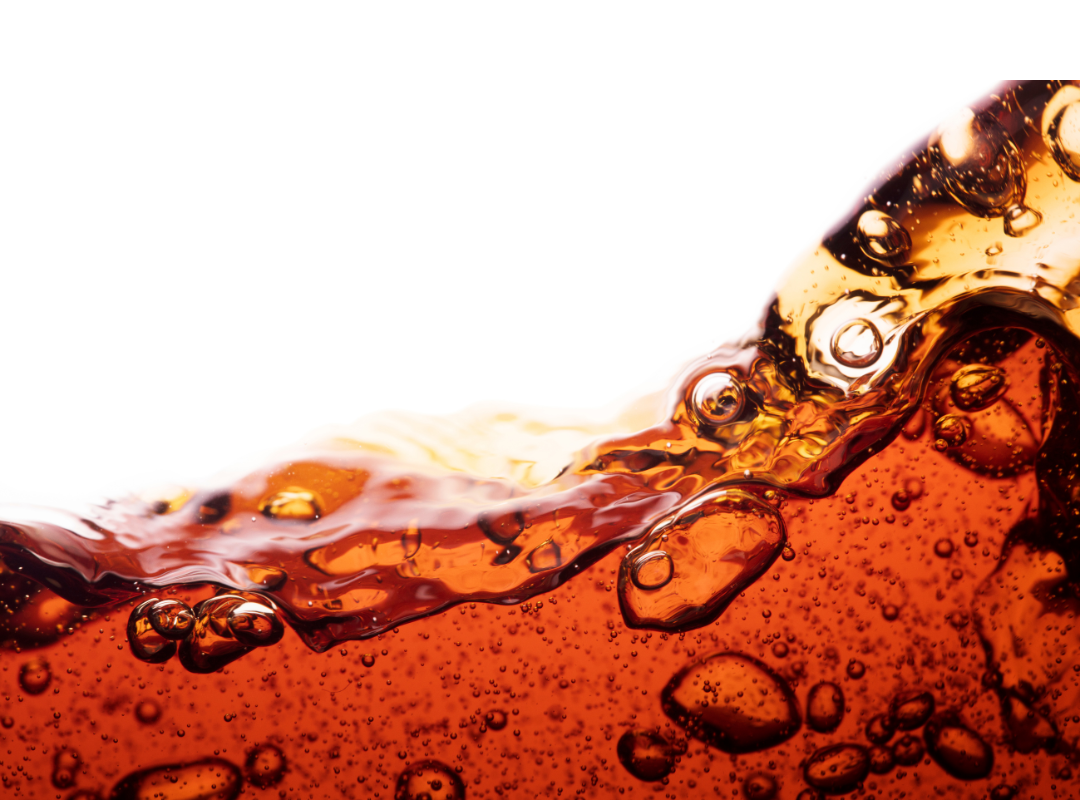 Close-up of amber soda splashing with bubbles against a white background