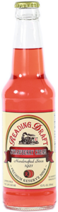 Glass bottle of clear pink soda with a vintage red-and-cream label and metal cap.
