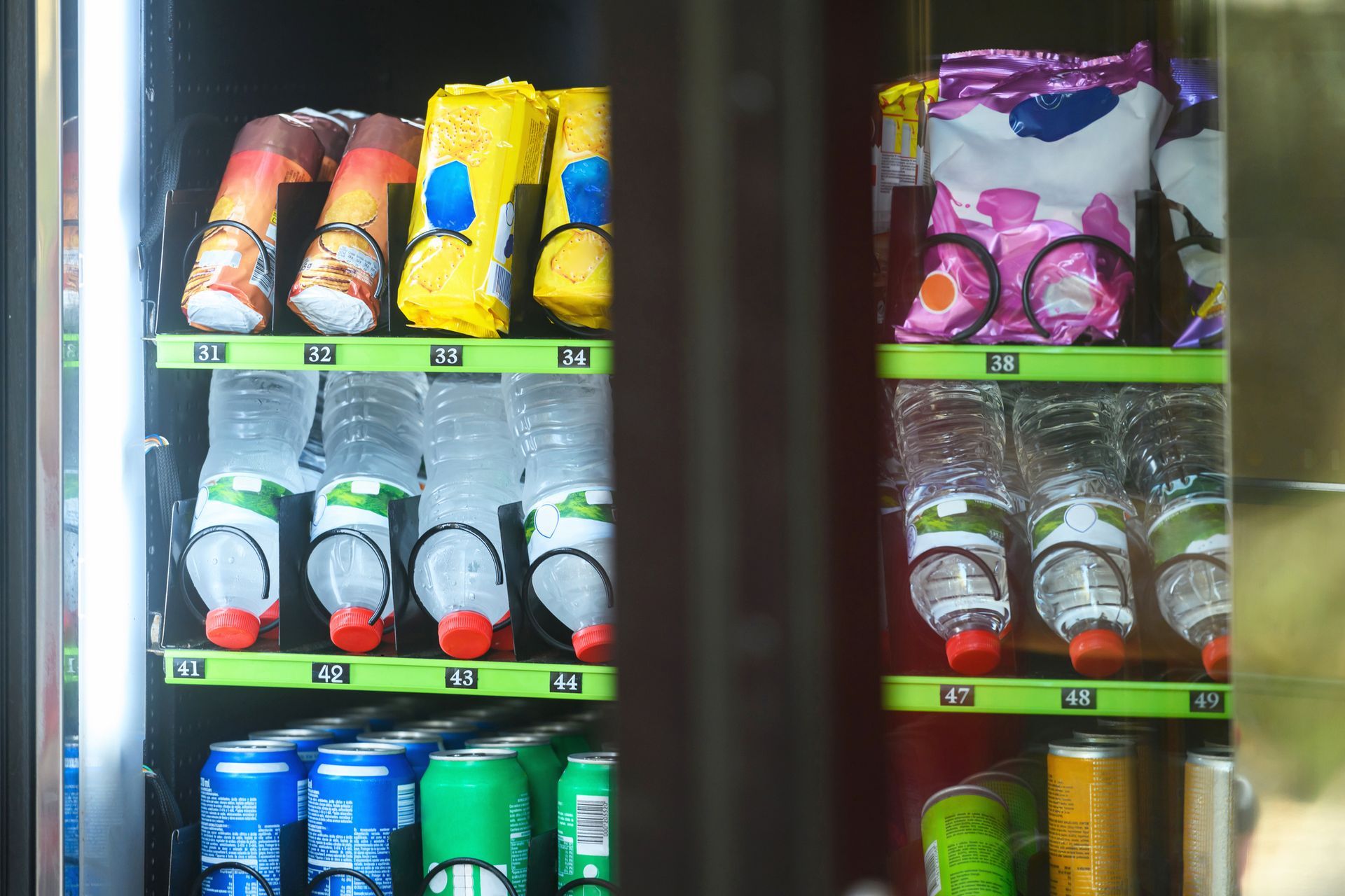 A vending machine filled with bottles , cans , and snacks.
