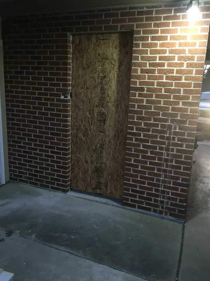 Brick wall with a boarded-up door.