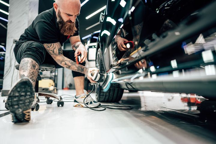 A man is working on a car in a garage.