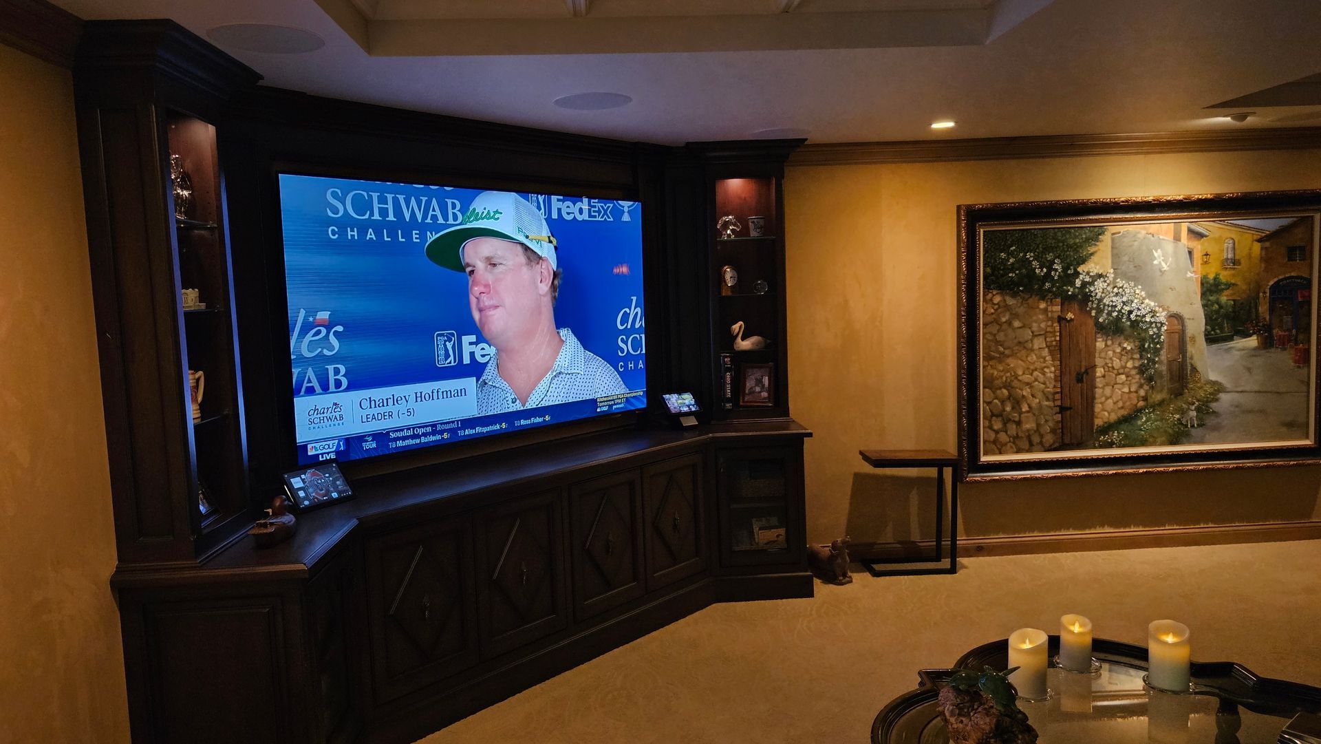 A man is playing golf on a large screen in a living room.
