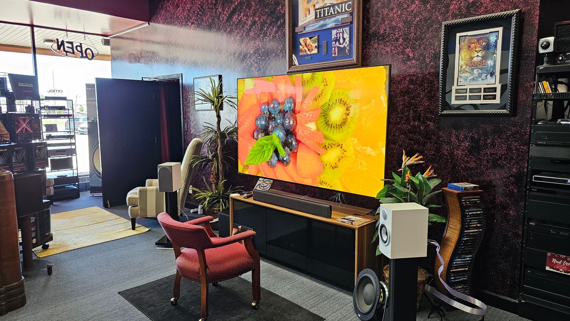 A living room with a chair and a television on the wall.