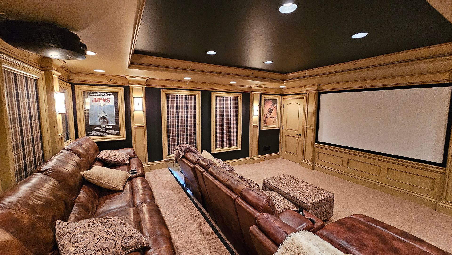 A home theater with a large couch and a projector screen.