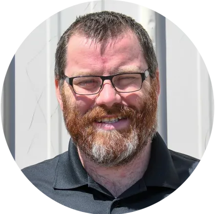 A man with a beard and glasses is smiling in a circle.