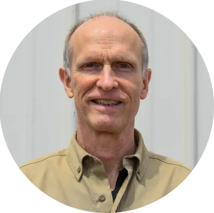 A man in a tan shirt is smiling in a circle