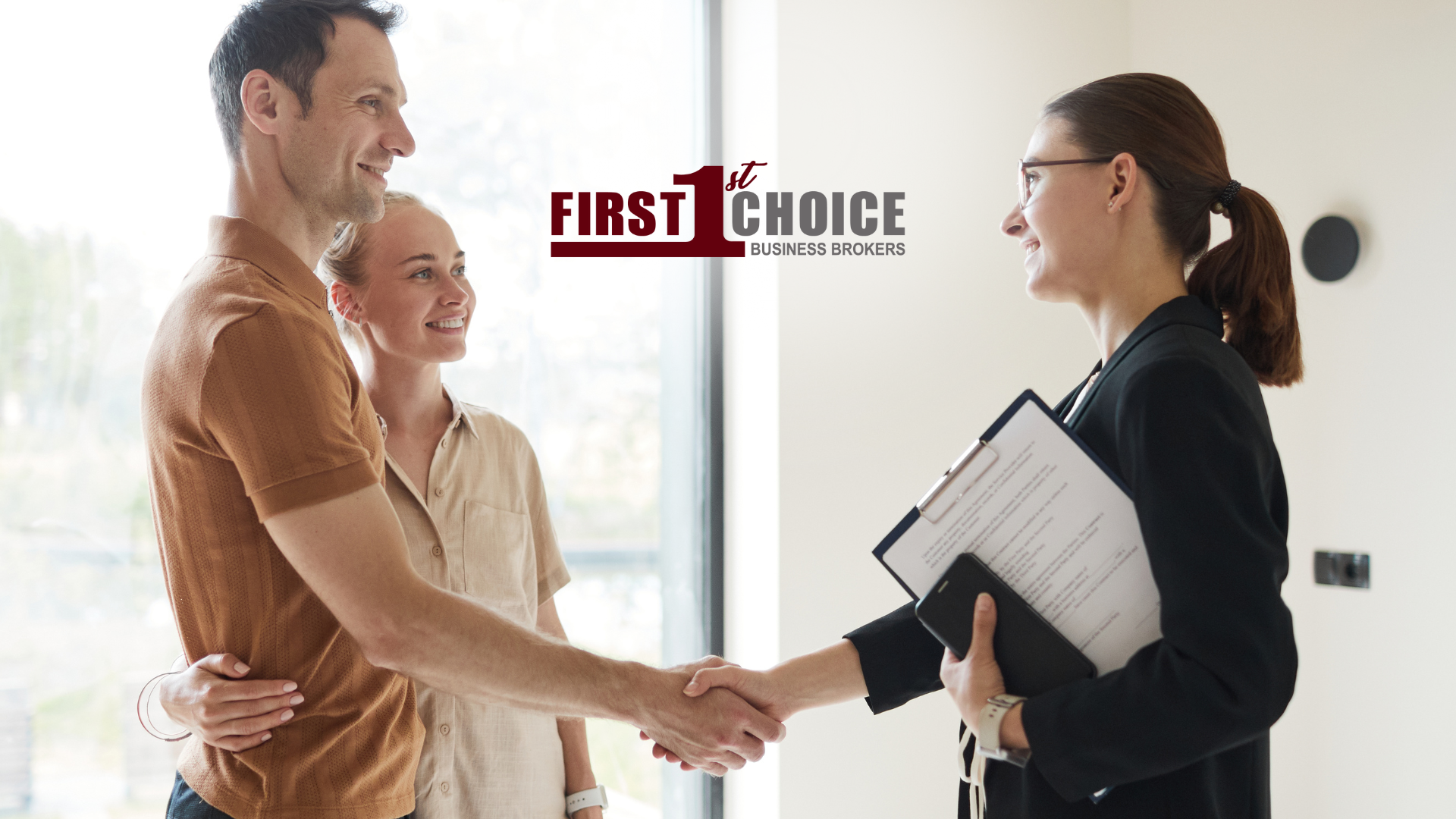 A man and woman are shaking hands with a real estate agent.