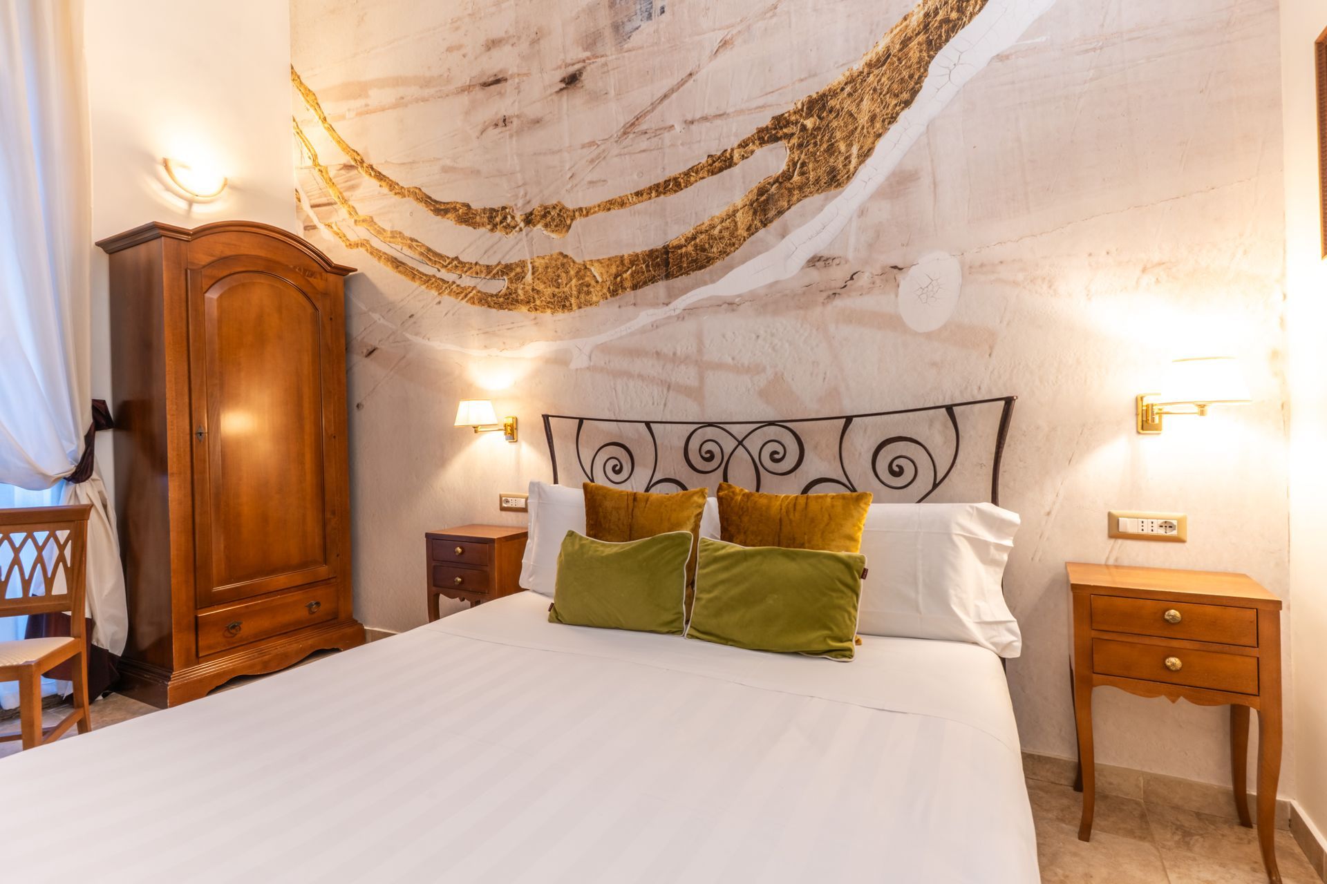 Schlafzimmer mit großem Bett, Holzschrank, Nachttischen und abstrakter Wandkunst in neutralen Tönen.