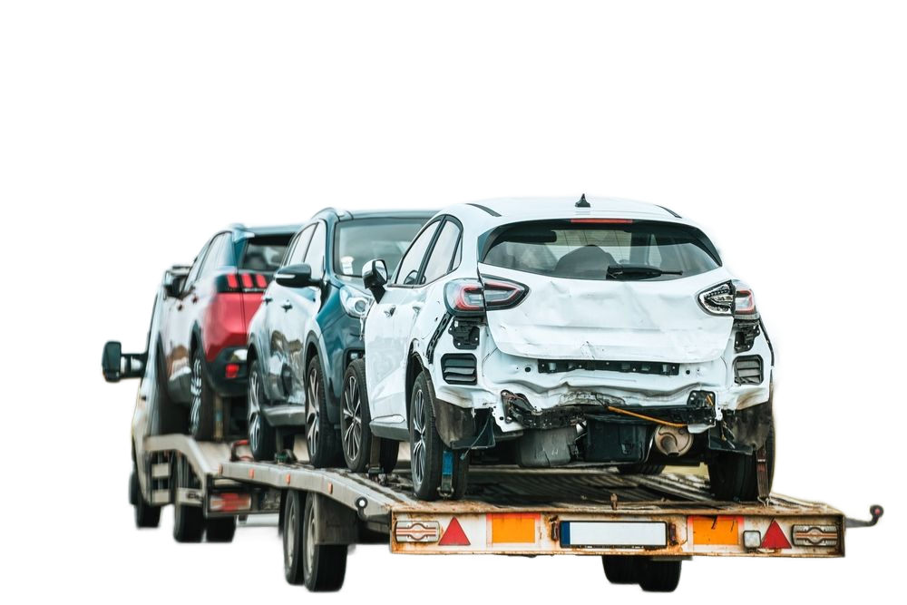 A flatbed trailer carries three cars, including a damaged white hatchback at the rear, against a white background.