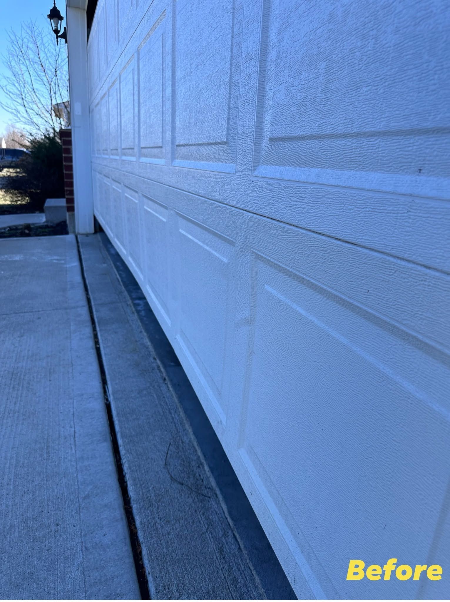 Narrow sidewalk beside a white stucco wall with a dark expansion joint, marked “Before” in the corner.