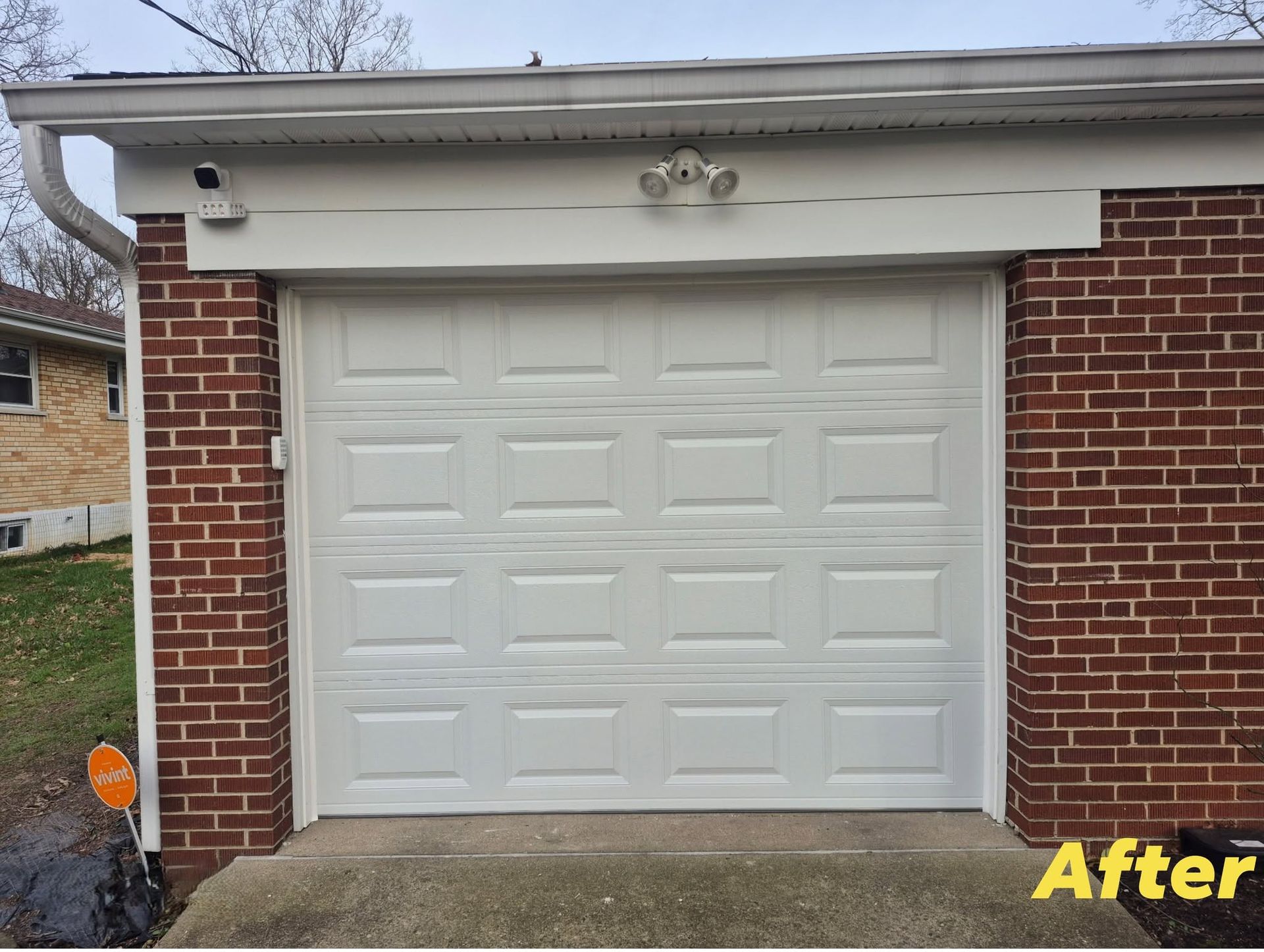 White garage door on a brick house with a “After” label in the bottom right.