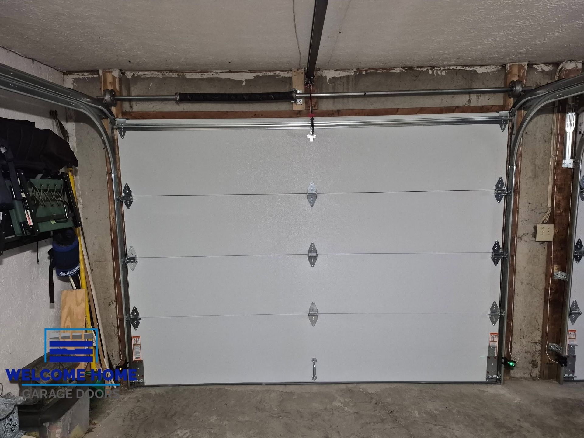 White sectional garage door with five panels in a workshop or garage opening.