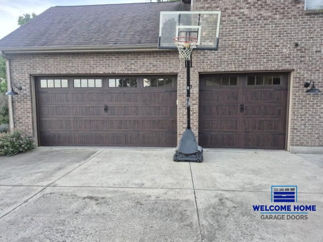 Suburban house with a two-car garage and portable basketball hoop in the driveway.