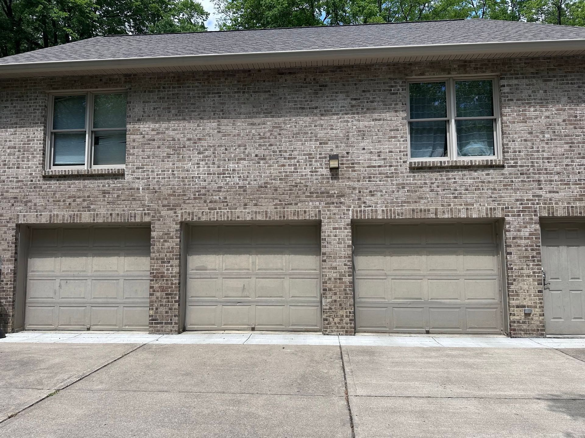 Two-story brick apartment building with three garage doors and two upstairs windows