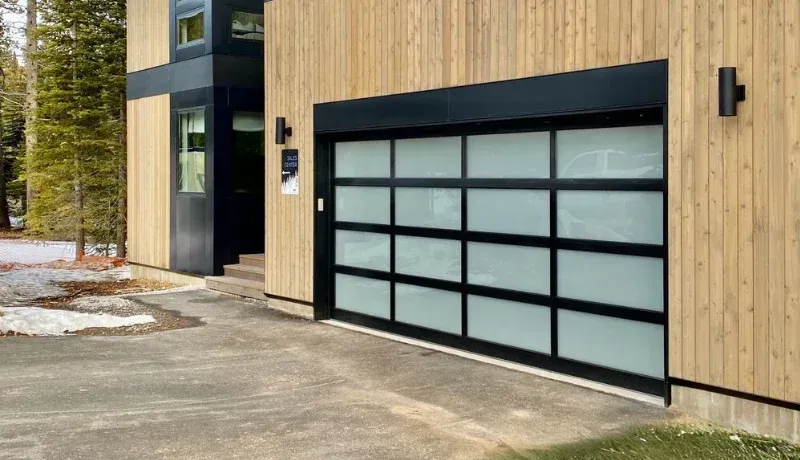 Modern home exterior with a frosted glass garage door and wood siding