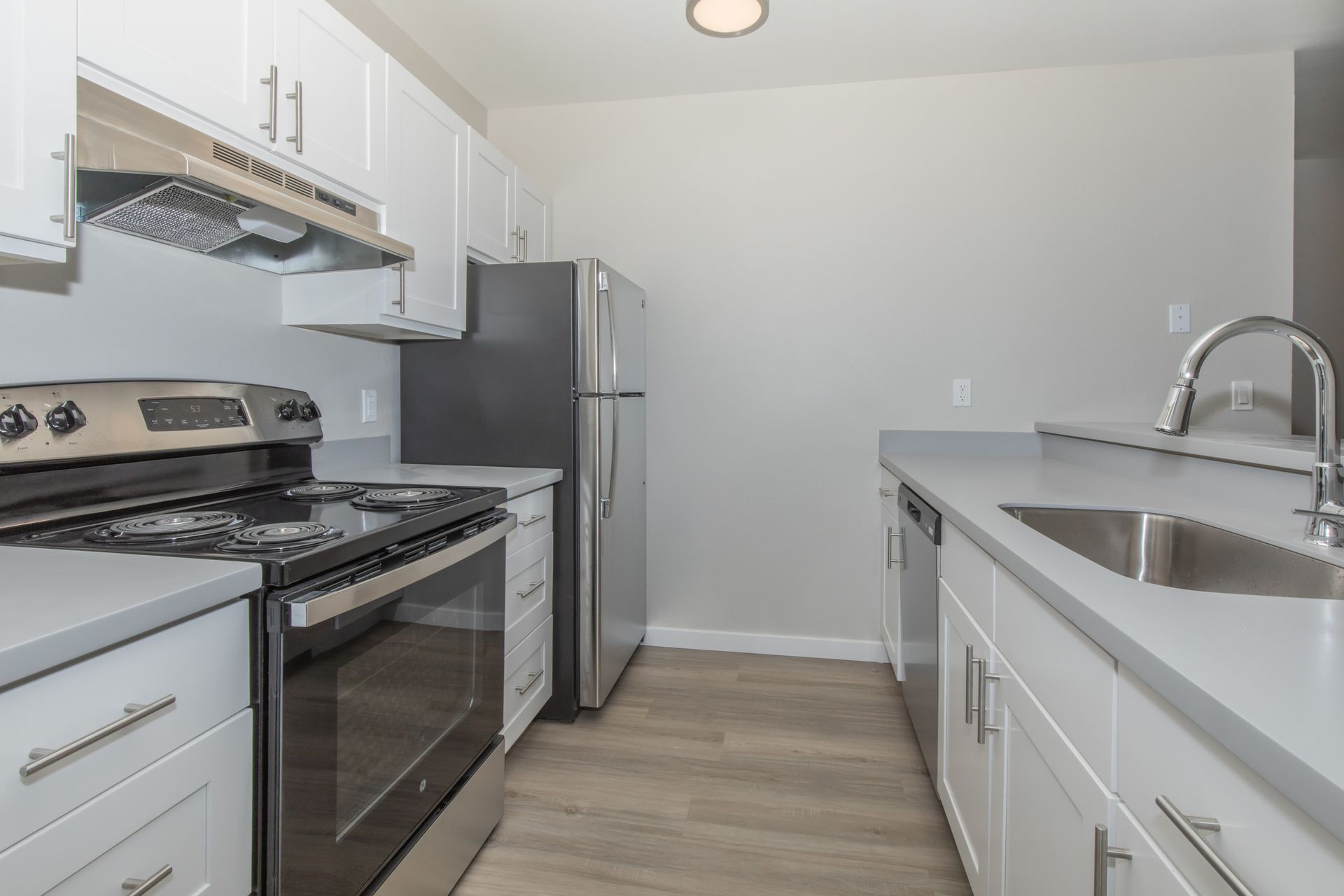 A kitchen with a stove , refrigerator , sink and dishwasher.