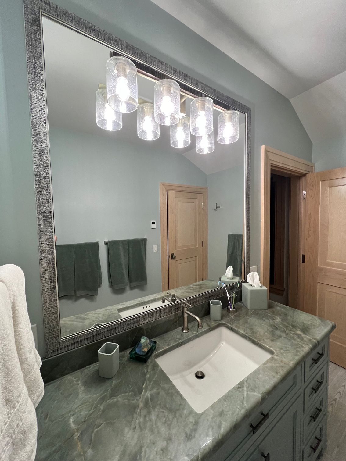 A bathroom with a sink and a large mirror