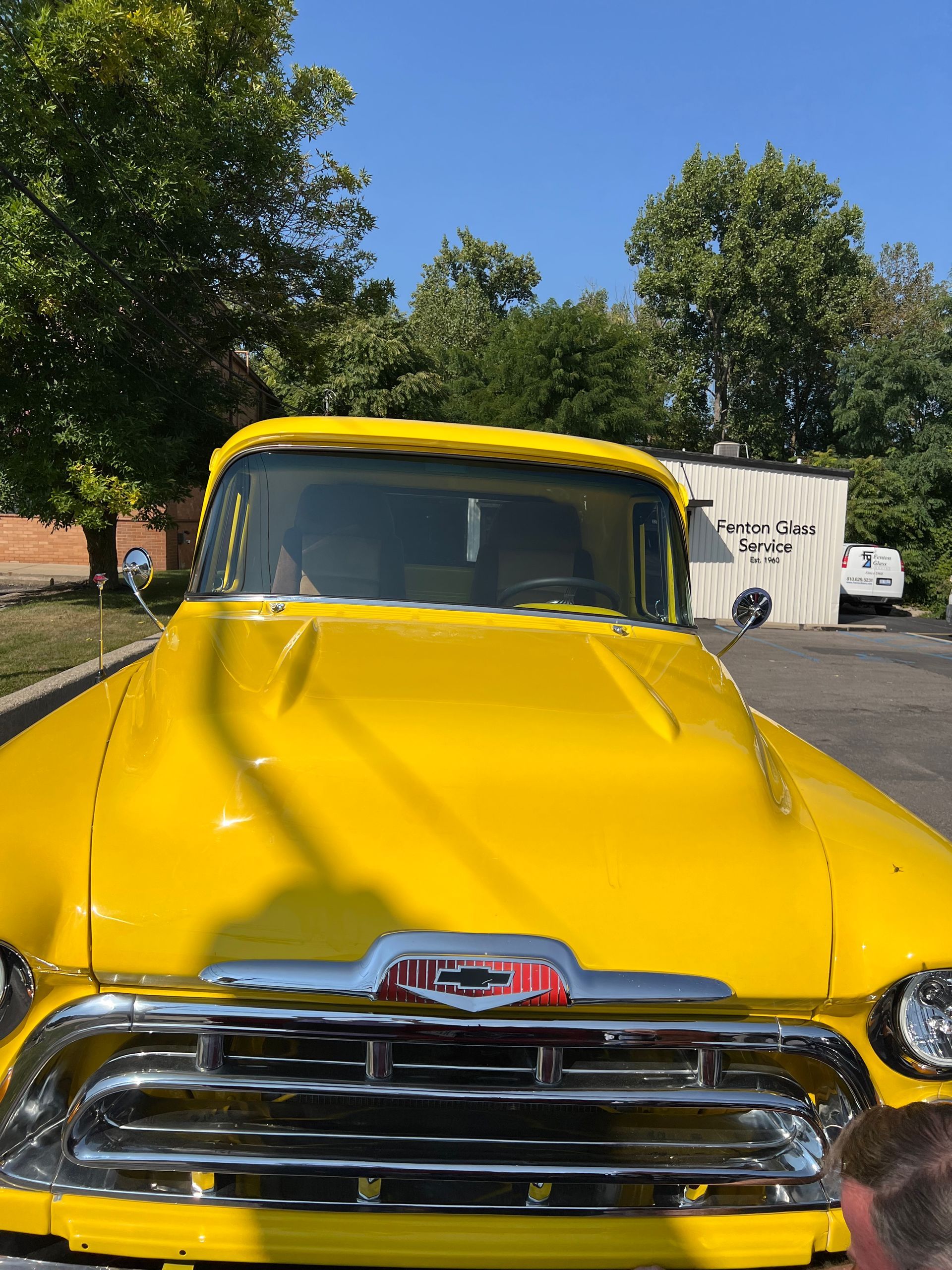 Bright yellow vintage GMC truck with chrome grill and hood.