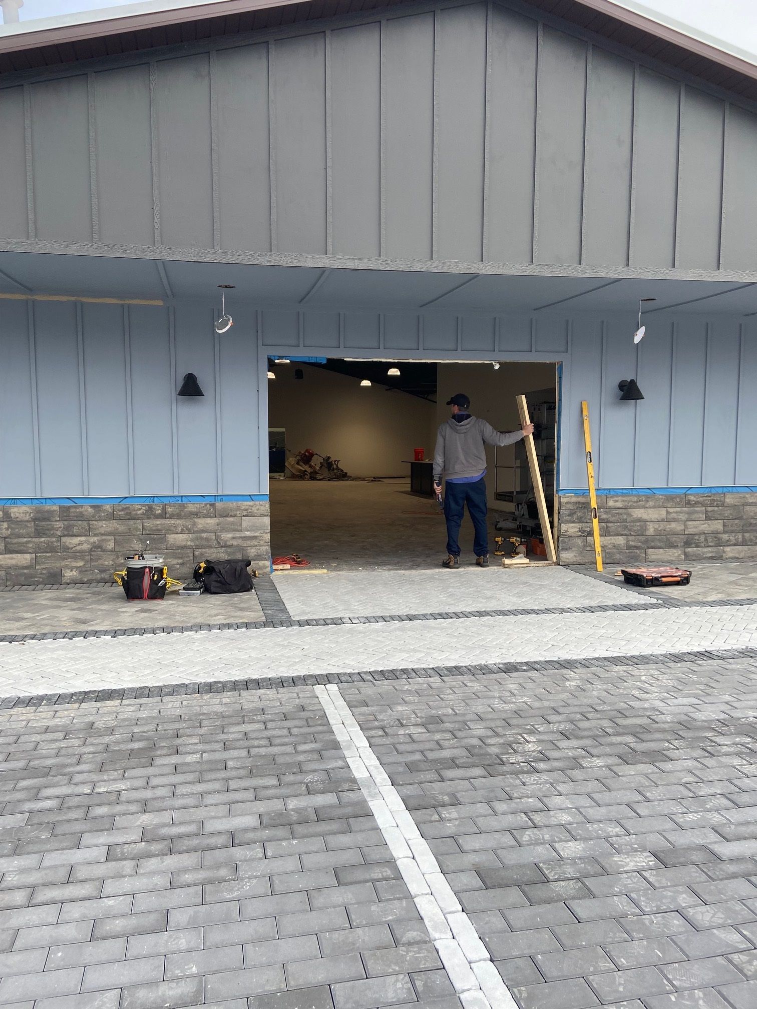 A man is standing in front of a building that is being built with a glass entry.