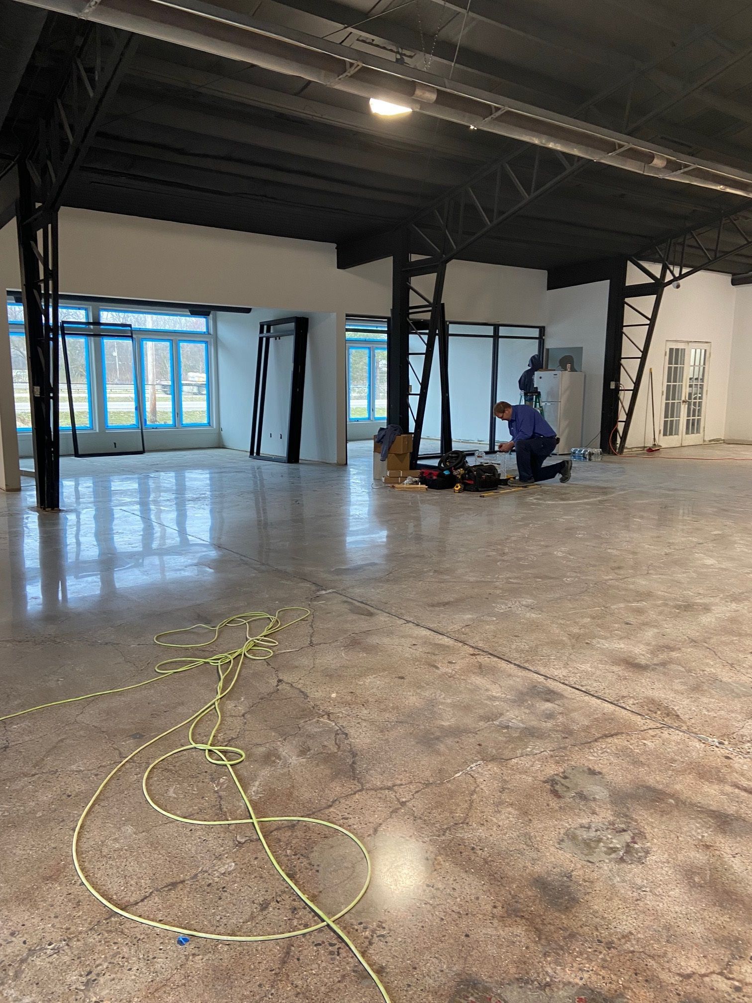 A man is working on the floor of a large room.