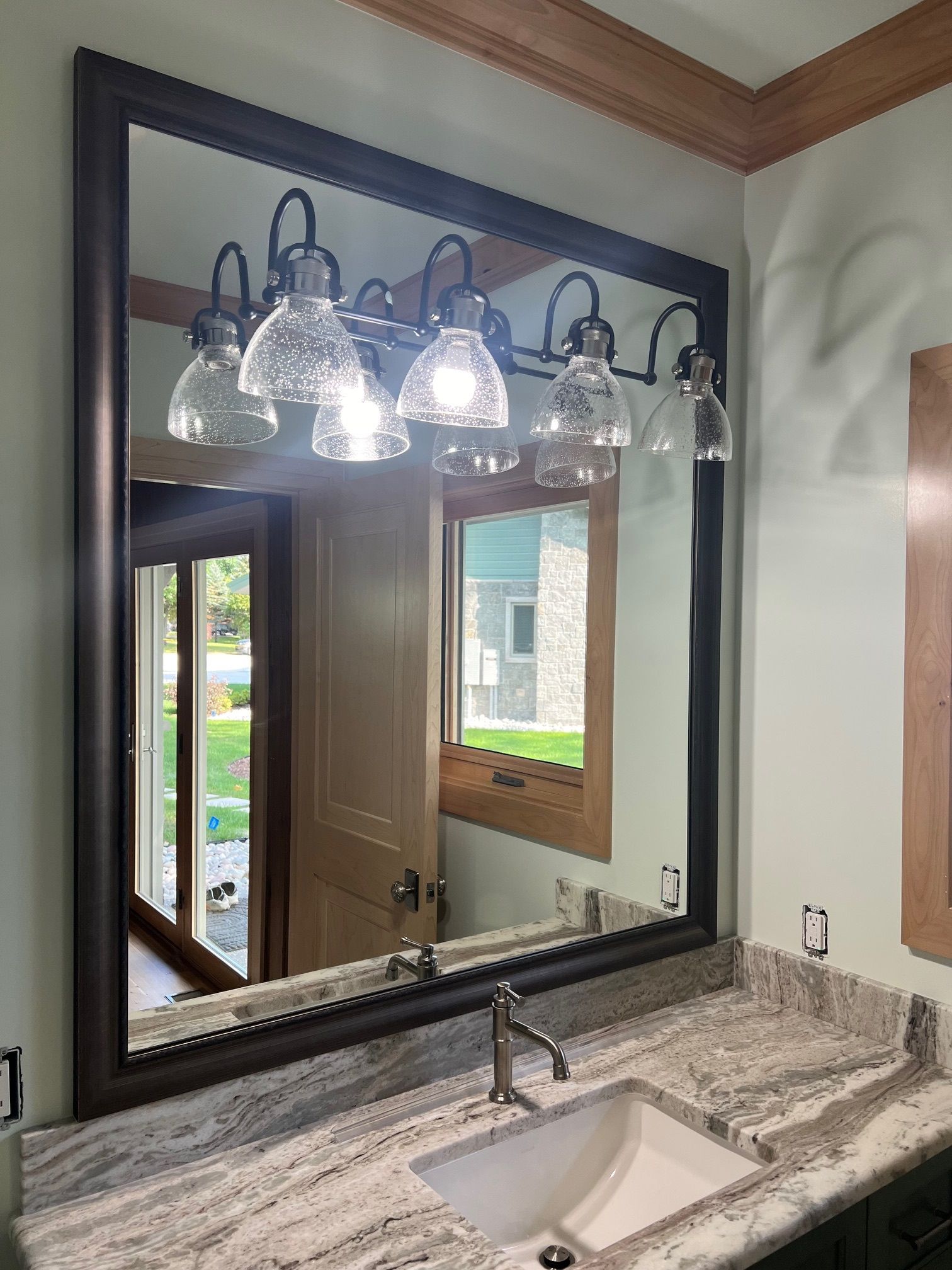 A bathroom with a large mirror and a sink.