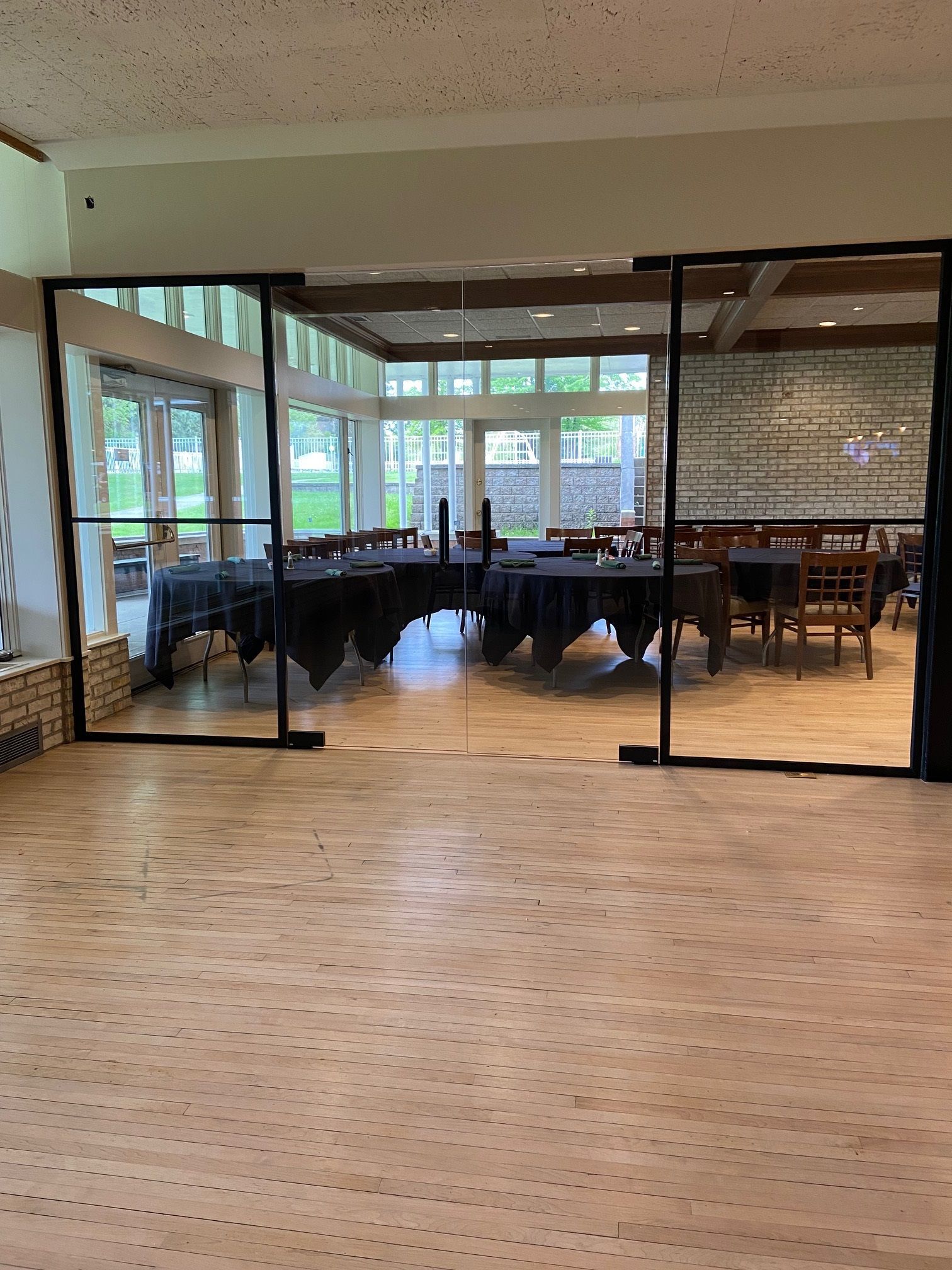A large room with tables and chairs in it behind a glass wall.
