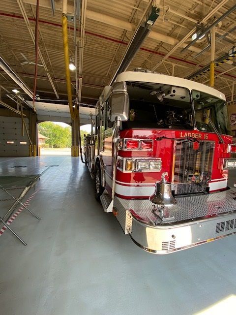 Red fire truck parked inside a fire station bay.