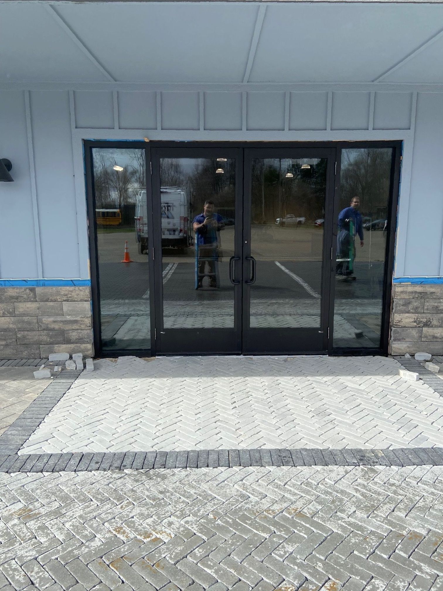 A man is standing in front of a large glass door.