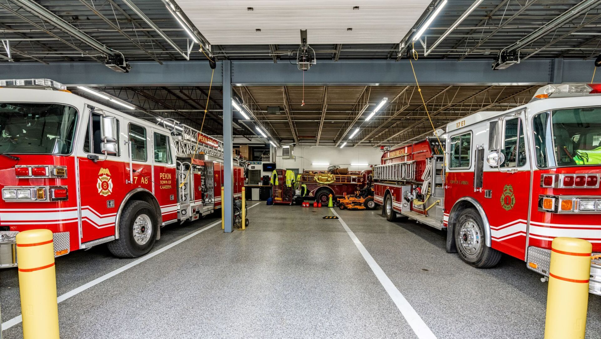 A row of fire trucks are parked in a garage.