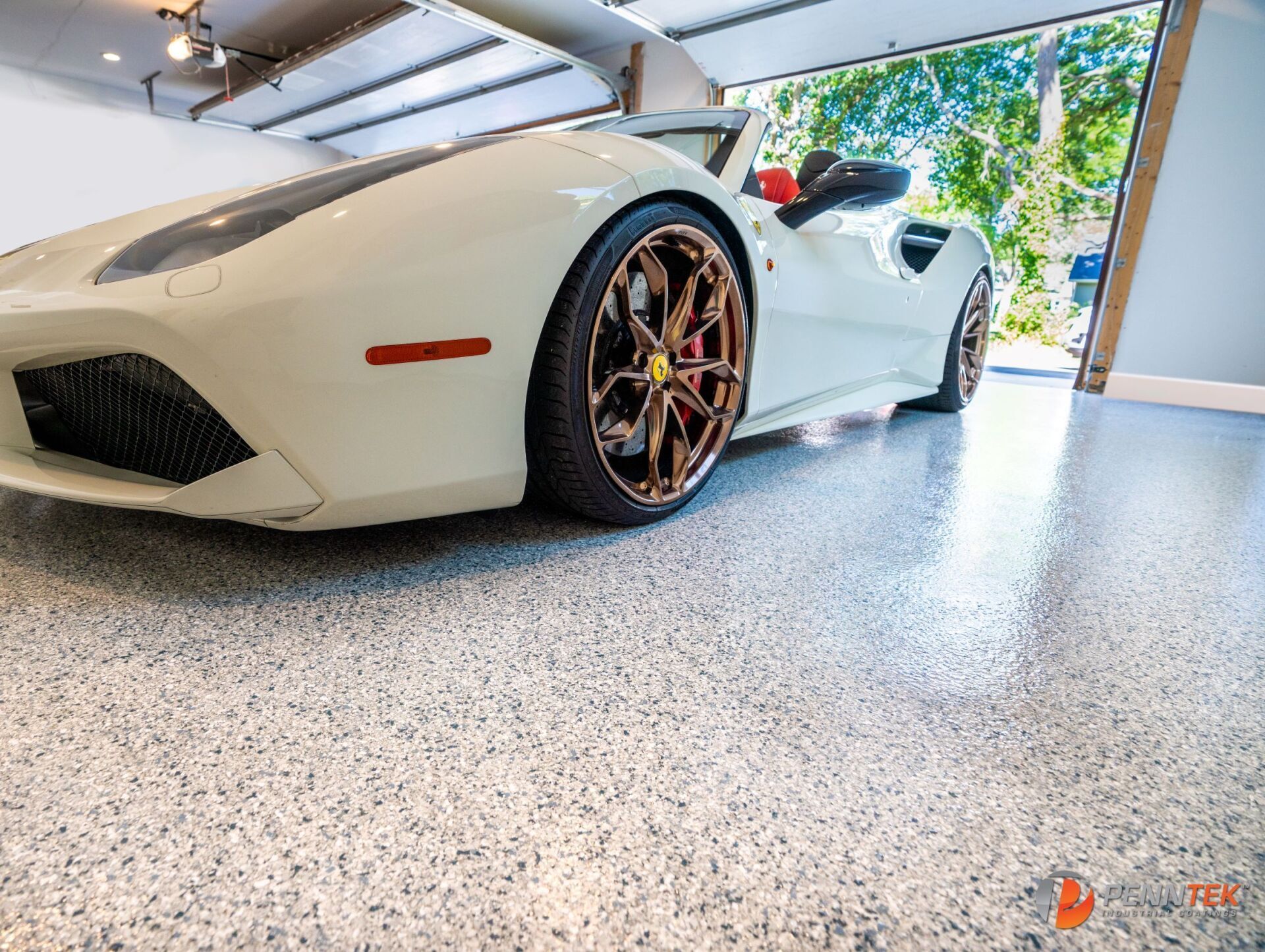 A white sports car is parked in a garage.