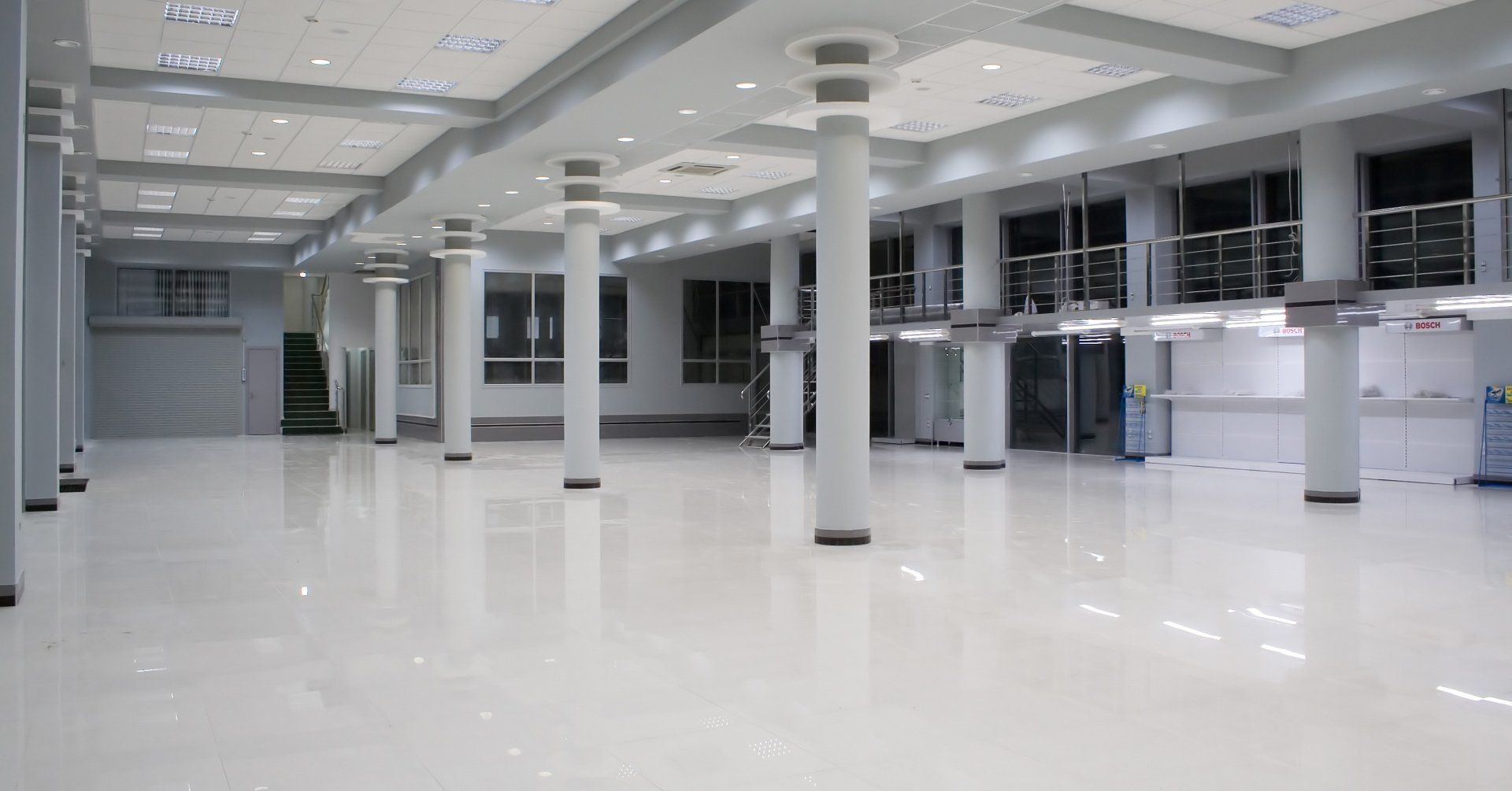 A large empty room with columns and a lot of windows.