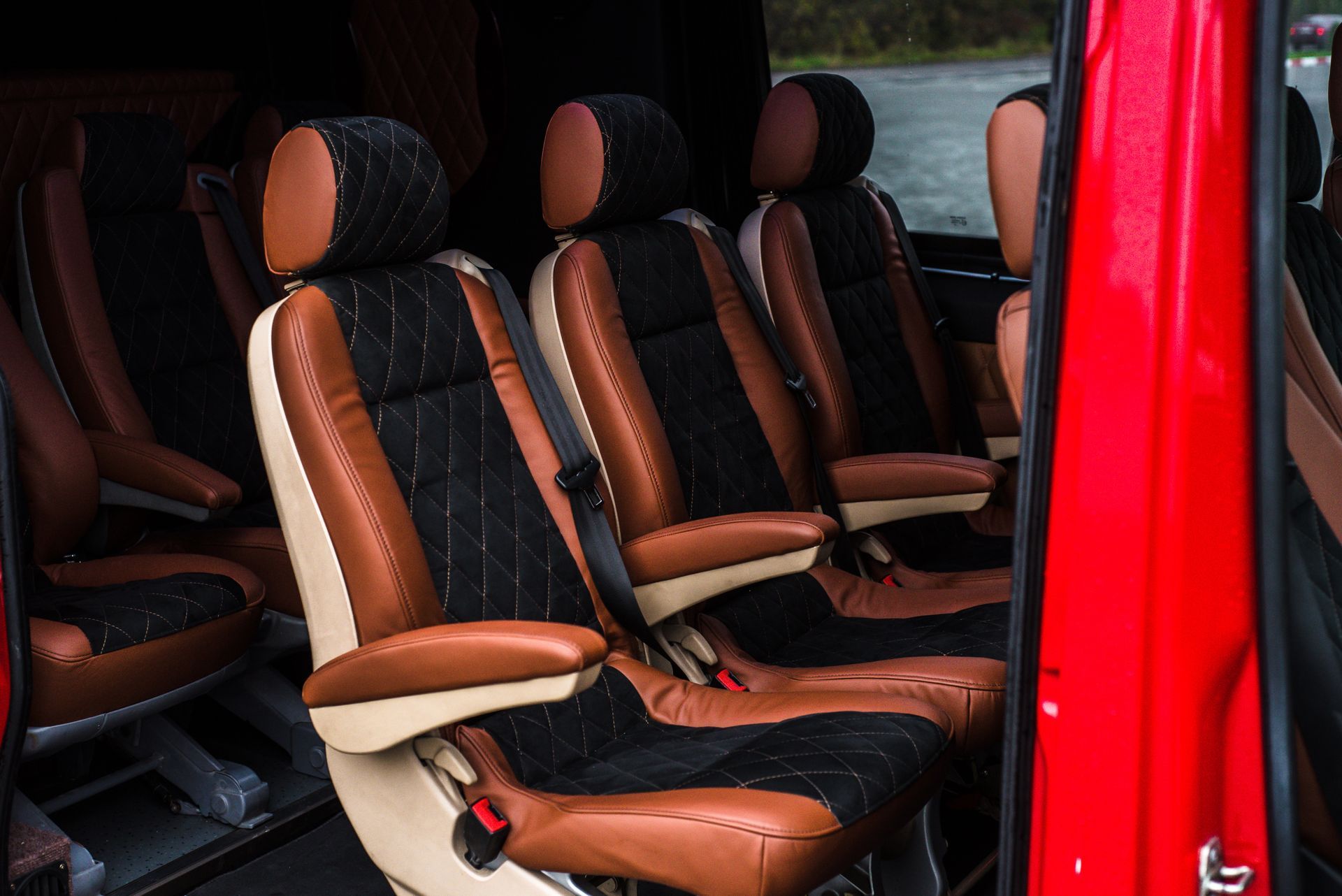 Red van interior with tan-and-black seats arranged in rows