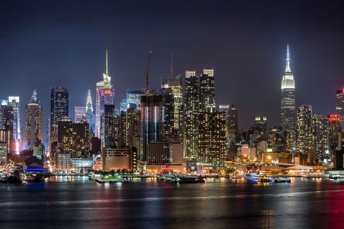 The skyline of new york city is lit up at night