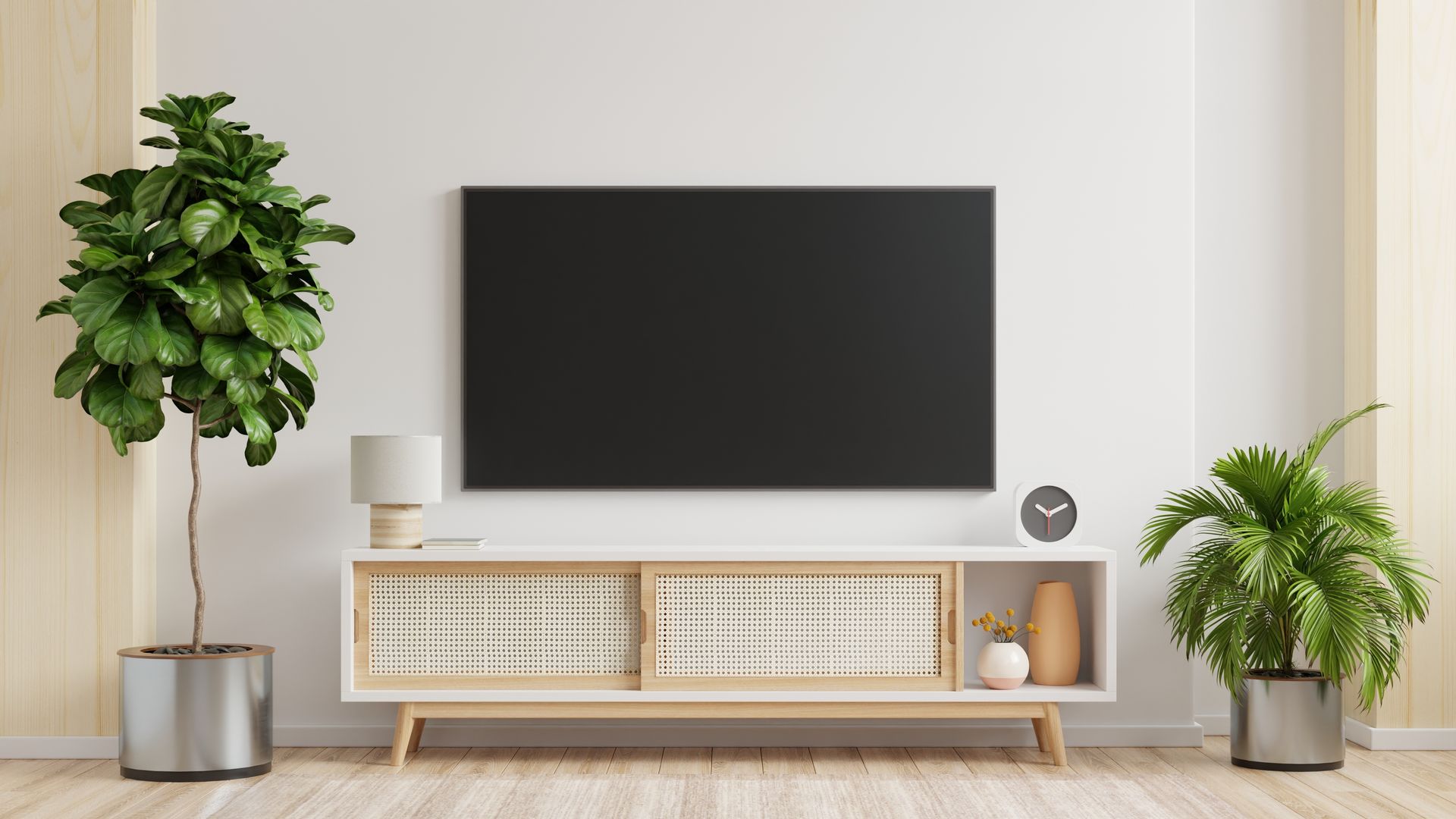 Modern living room with wall-mounted TV, low media console, potted plants, and neutral decor