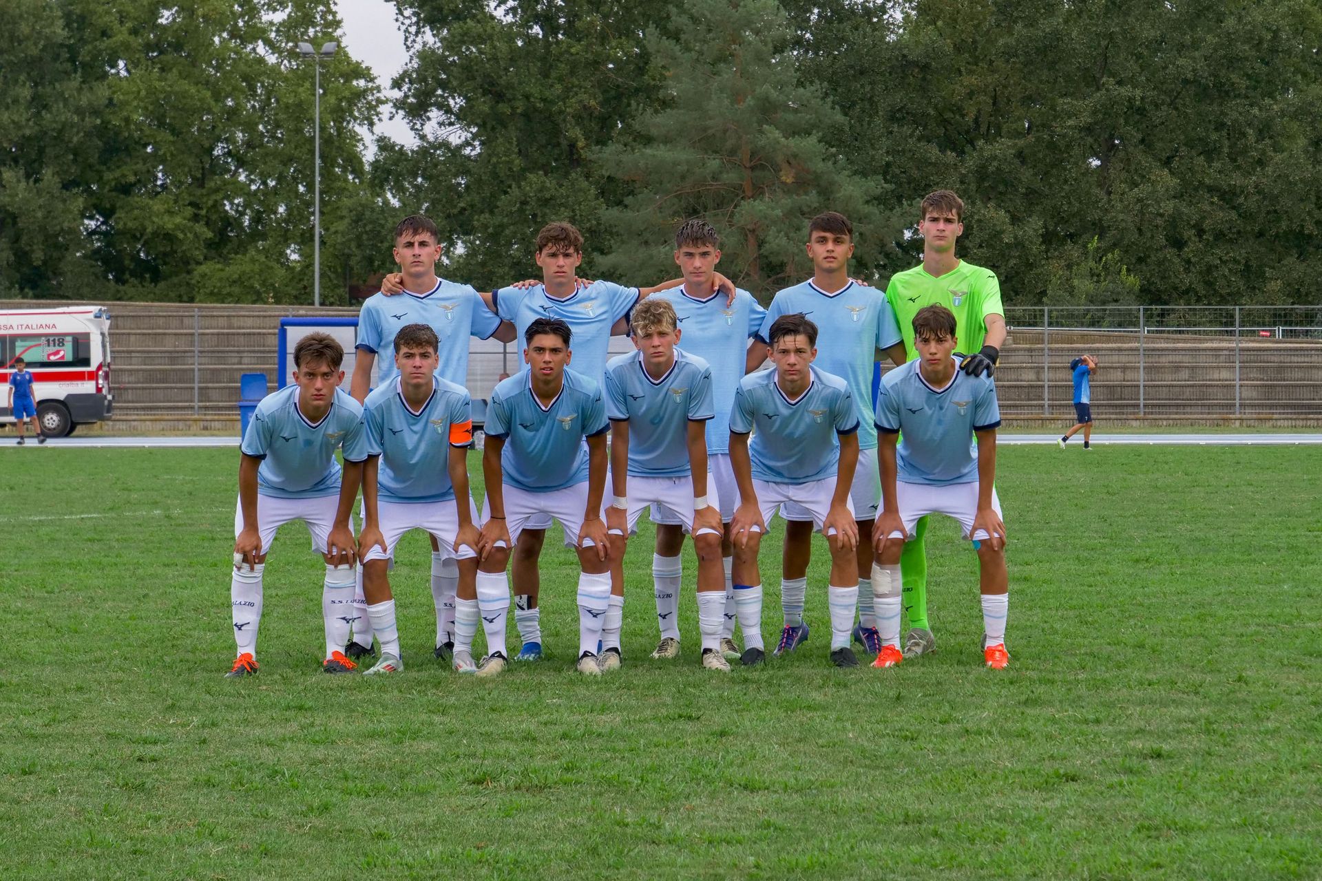 La squadra di calcio in maglia azzurra posa su un campo.