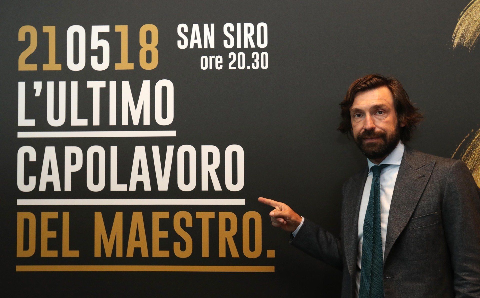 Andrea Pirlo indica un cartello che pubblicizza la sua partita d'addio allo stadio San Siro.