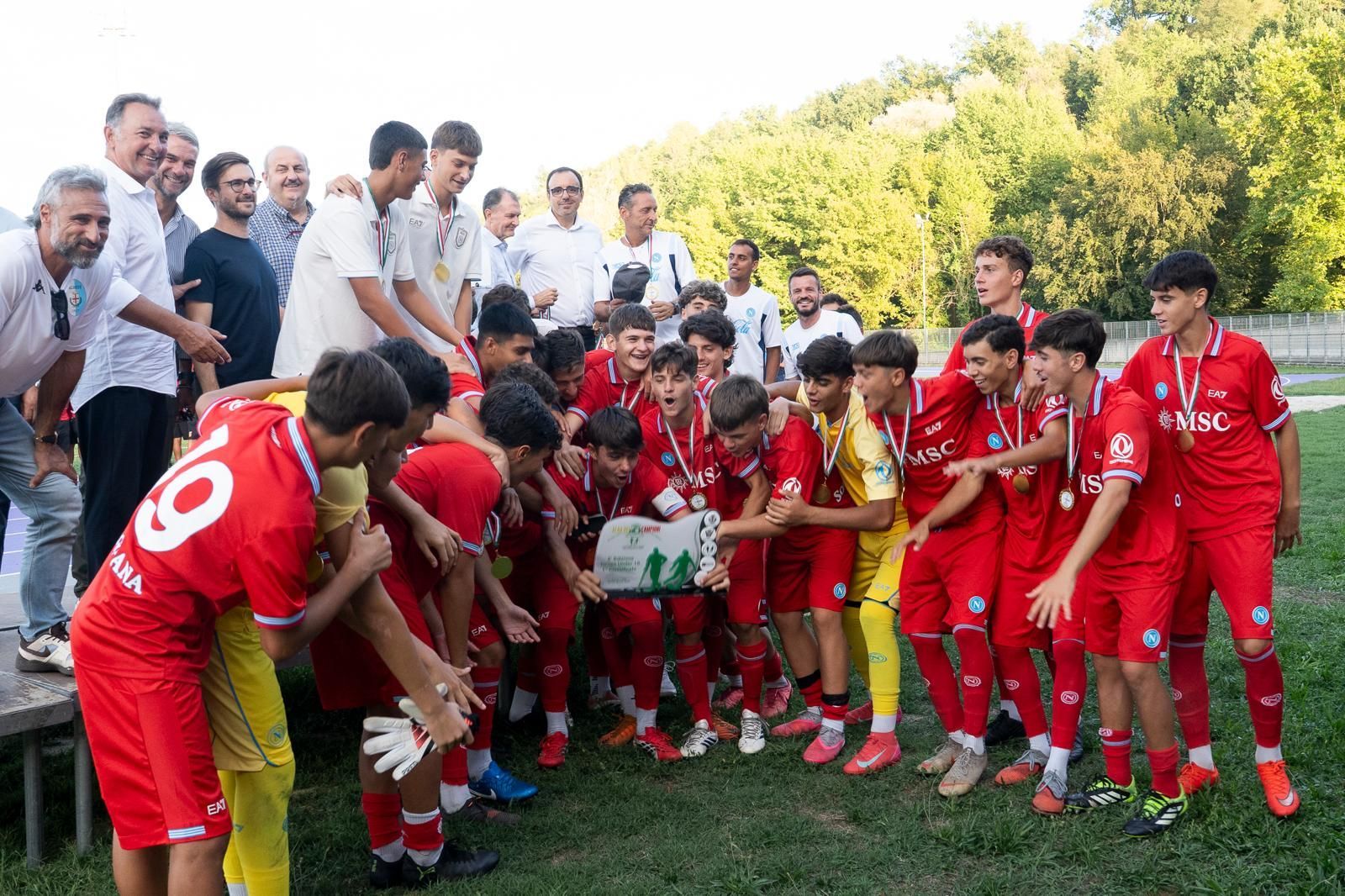 Giocatori di calcio in divisa blu e nera festeggiano un gol su un campo verde.