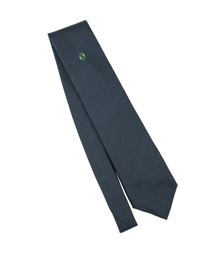 Cravatta blu con piccolo stemma verde.
