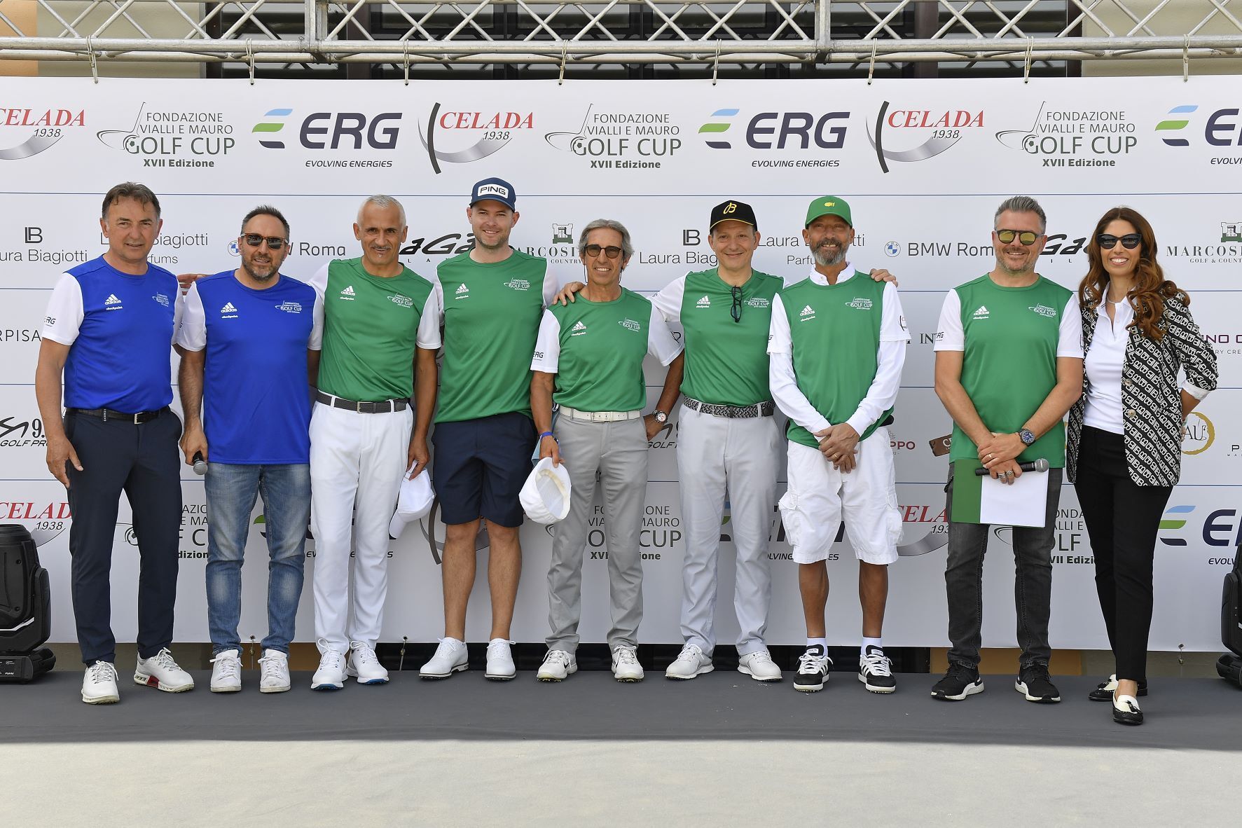 Gruppo di persone in tenuta da golf in piedi davanti a uno striscione.