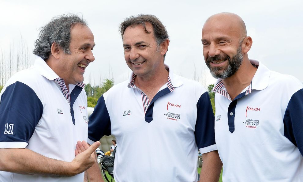 Tre uomini in polo all'aperto, sorridenti e chiacchieranti.
