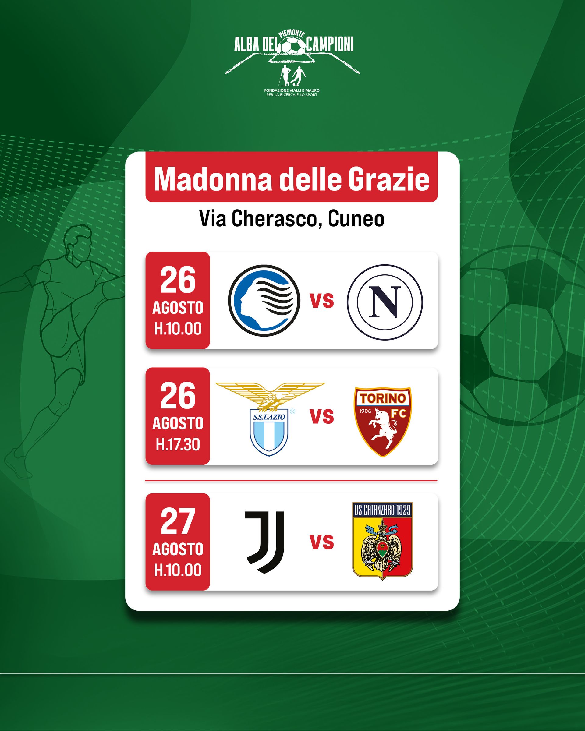 Quattro uomini sono in piedi su un palco, uno dei quali parla al microfono. Sono all'aperto, con un campo da calcio e alberi sullo sfondo.