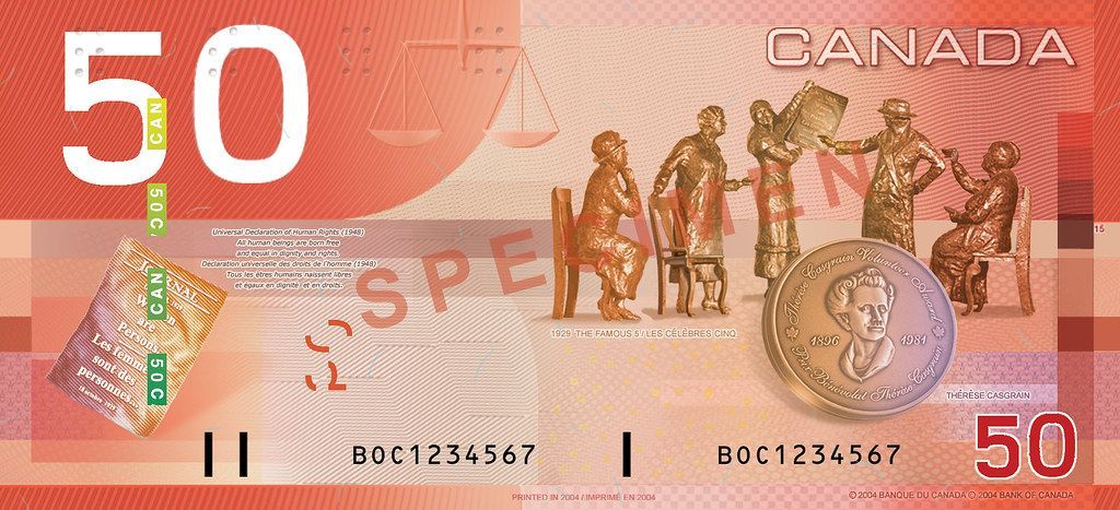 A 50 canadian dollar bill with a coin on it