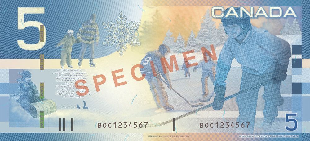 A canadian five dollar bill with a hockey player on it