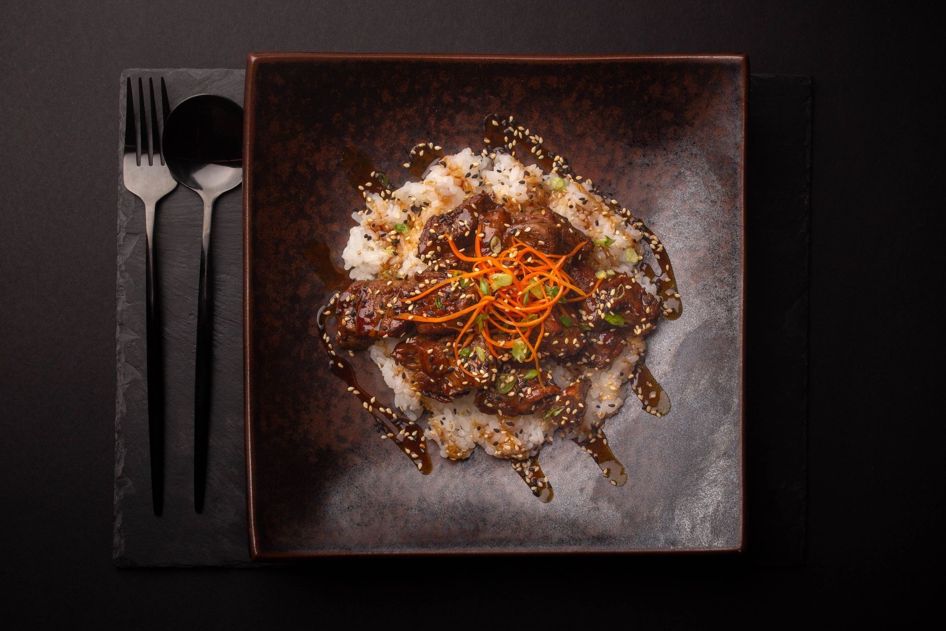 Sushi Restaurant | Finding Sushi | Plated gourmet dish with rice and sauce on a black square plate